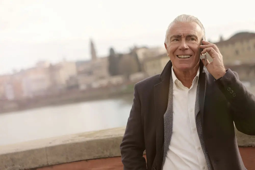 Homem sorrindo enquanto fala ao celular